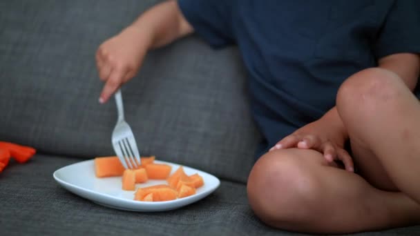 Kleiner Junge Isst Melonenfrucht Auf Sofa — Stockvideo
