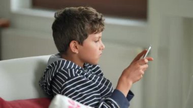 Küçük çocuk tabletle oyun oynuyor. Çocuk teknoloji aygıtında video oyunu oynuyor