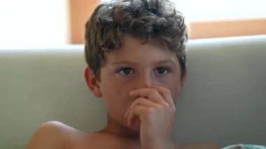 Genç çocuk TV seyrediyor, çocuk eğlence programına bakıyor.