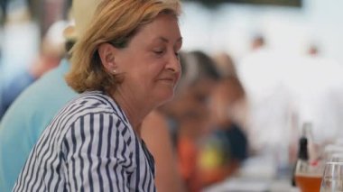 Son sınıf öğrencisinin portresi başını kameraya çevirip gülümsüyor. Yaşlı kadın kameraya bakıyor.