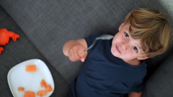 Criança Feliz Comendo Frutas Melão Sentado Sofá Olhando Para Câmera — Vídeo de Stock