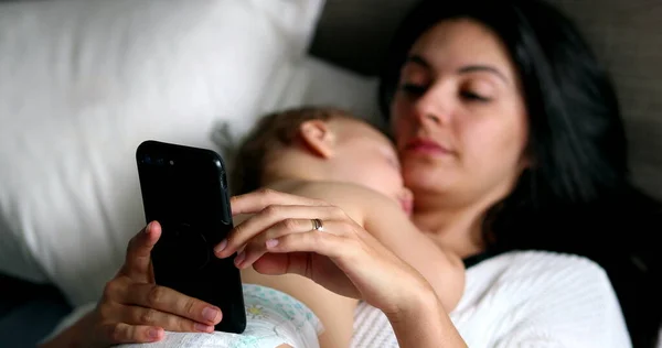 Candid Mother Looking Smartphone While Baby Infant Naps — Photo