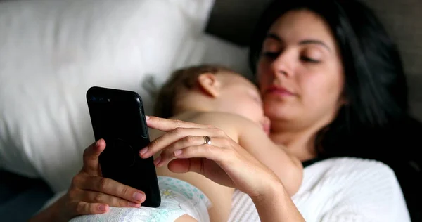 Candid Mother Looking Smartphone While Baby Infant Naps — 스톡 사진