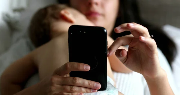 Повсякденна Мати Використовує Мобільний Пристрій Спальні Сплячою Немовлям — стокове фото