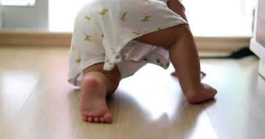 Baby infant child development crawling on hardwood floor at home