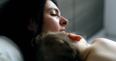 Baby and mother togetherness in bed sleeping