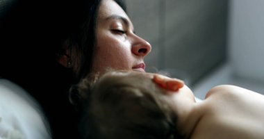 Baby and mother napping lying in bed