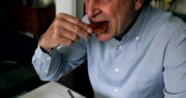 Older man eating toast bread with jelly in breakfast morning