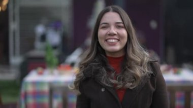 Dışarıda paltoyla duran sıradan bir genç kadın. Güney Amerikalı 20 'li yaşlarda Latin bir kızın portresi.