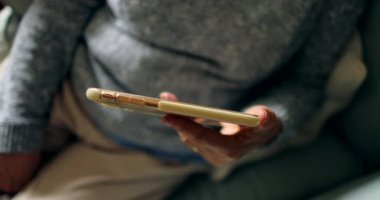 Cep telefonunu tutan kişi içeriği çevrimiçi izliyor