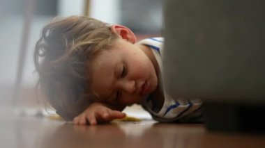 Angry little boy lying on floor feeling upset and boredom at home