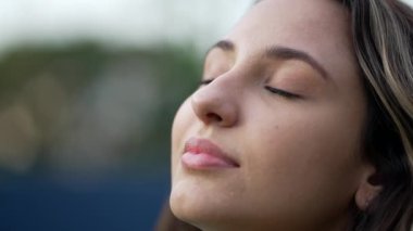 Genç İspanyol kadın meditasyonda gözlerini kapatıyor. Yirmili yaşlarda bir kız gözlerini açtığında gülümsüyor. Yakından bir kadın yüzü