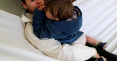 Anne ve çocuk birlikte hamakta.