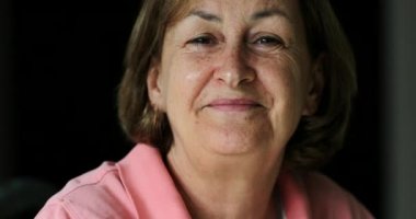 Kameraya gülümseyen son sınıf öğrencisi mutlu yaşlı bir kadın.