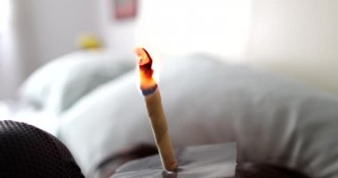 Kulak kiri temizleyen kişi kulak mumu tutuyor.