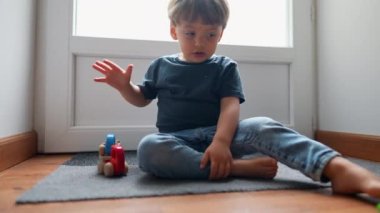 Çocuk evde oyuncakla oynuyor.
