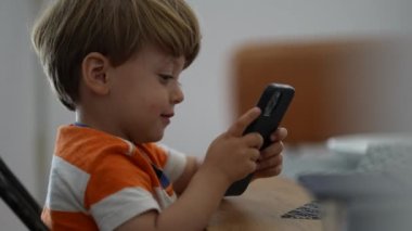 Telefon kullanan çocuk elinde akıllı telefon tutan küçük çocuk.