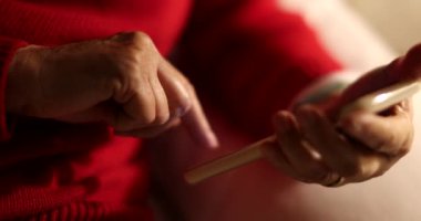 Akşamları teknolojiyi kullanan yaşlı kişi akıllı telefon aygıtı kullanıyor