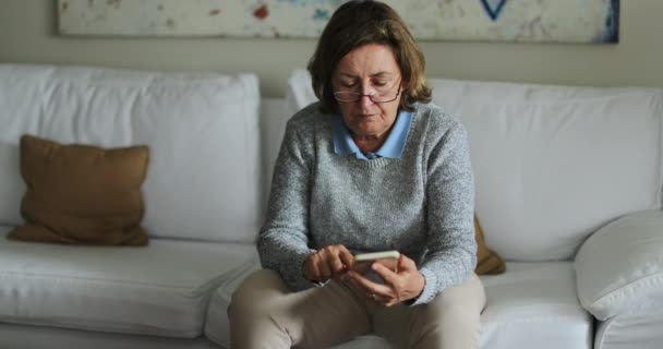 Senior Vrouw Met Behulp Van Technologie Zitten Bank Thuis Oudere — Stockvideo