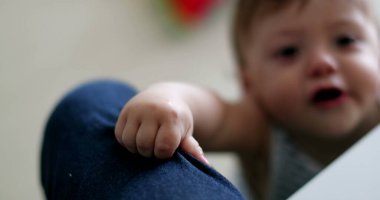 Effortful cute baby infant learning to stand, toddler boy child development