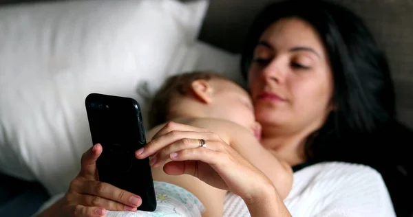 Parent Using Cellphone While Baby Asleep Chest — Photo