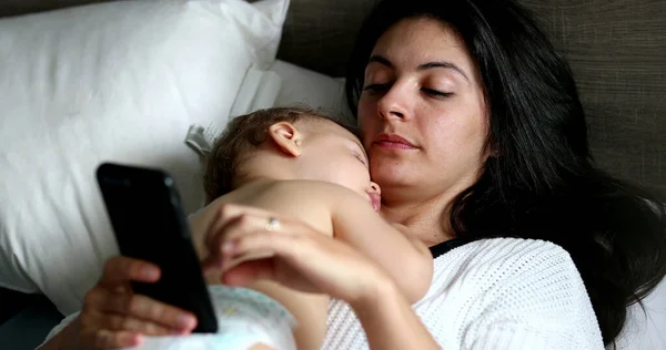 Mother Using Cellphone Device Home Lying Bed Sleeping Baby Chest — Foto Stock