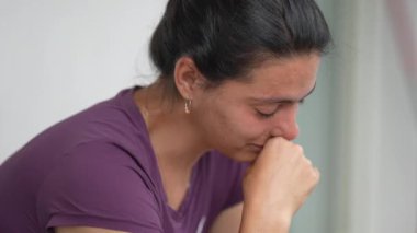 Ağlayan anne gözyaşlarını silmekte zorlanıyor.