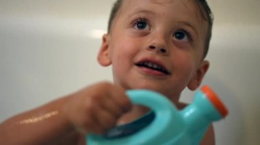 Küçük çocuk banyo küvetinde oynuyor.
