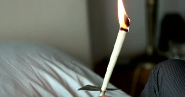 Kulak kirini çıkarmak için yanan koniyi tutan kadın.