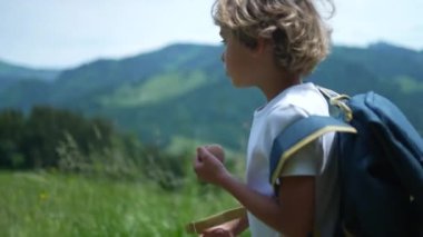 Dağlarda yürüyüş yapan küçük bir çocuk Sırt çantasıyla doğa yürüyüşü yapıyor