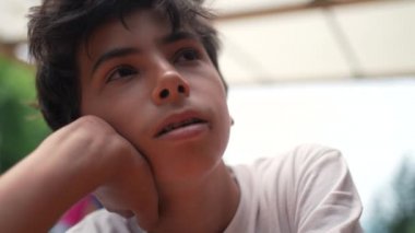 Düşünceli genç bir çocuk düşünceli bir ifade düşünüyor.