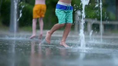 Çeşmede koşan çocuk yaz günü eğleniyor.