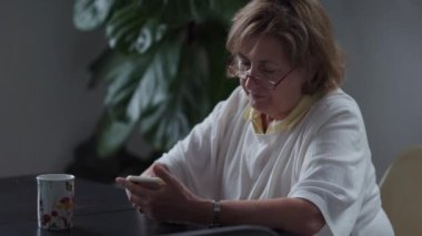 Cep telefonu aygıtına mesaj yazan samimi bir yaşlı kişi