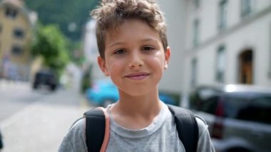 Sınıfa sırt çantasıyla gidip gelen mutlu bir öğrenci.
