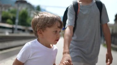 Dışarıda el ele tutuşan kardeşler.