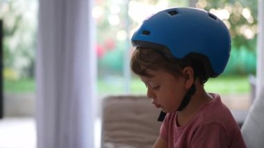 Bisiklet kaskı takan küçük çocuk.