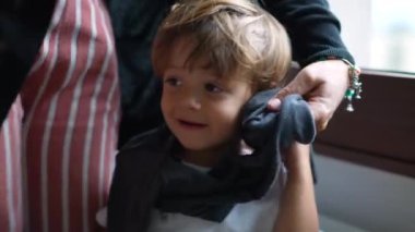 Anne çocuğu giydiriyor anne süveter giyiyor evlat.