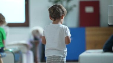 Küçük bir çocuk uzaktan kumandalı oyuncak arabasıyla oynuyor.