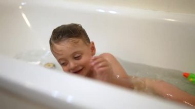 Küvetin içindeki küçük çocuk banyo yapıyor.