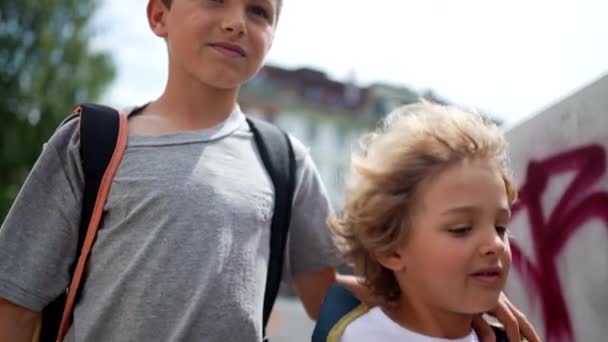 Δυο Νεαροί Αδελφοί Πηγαίνουν Μαζί Στο Σχολείο Κουβαλώντας Σακίδια — Αρχείο Βίντεο