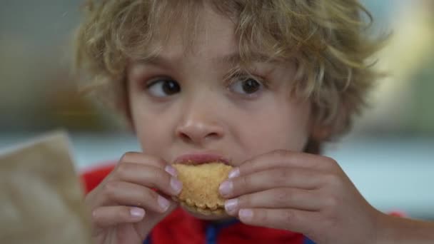 小さな男の子がクッキーを食べる — ストック動画