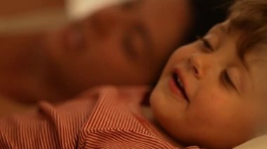 Çocuk ve anne gece yatağında uzanmış masal okuyan çocuk profili çiziyorlar.