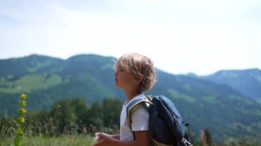Düşünceli bir çocuk dışarıda doğa yürüyüşü yapıyor.