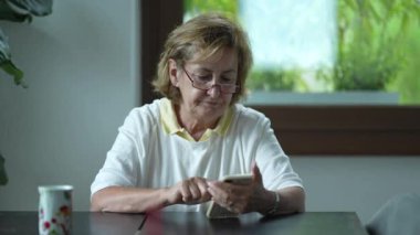 İnternette gezinen yaşlı bir kadın. Bir son sınıf öğrencisi akıllı telefon kullanıyor.