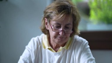 Son sınıf öğrencisi bir kadın evde telefonda içeriği okuyor.