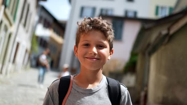 Ένα Χαρούμενο Όμορφο Νεαρό Αγόρι Που Περπατάει Στο Δρόμο Χαμογελώντας — Αρχείο Βίντεο