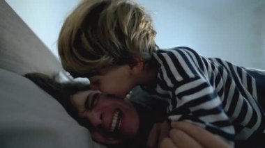 Child and mother in bed togetherness real life morning wake up