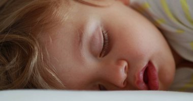 Baby sleeping. Cute infant face close-up asleep. Adorable one year old toddler boy napping macro closeup