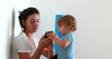 Baby talking on phone, infant with cellphone in ear, toddler giving smartphone to mom