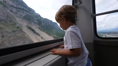 Çocuk içeriden manzaraya bakıyor.